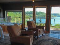 Two recliners in the foreground with emphasis on the lake view through the four large window that face Beaver Lake.