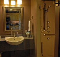 A vanity and the entrance to the roll in shower with 4-port body spray system in our accessible bathroom.