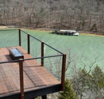 A view down onto one of the suspended, ipe (ironwood) decks of the Sky Suites complete with rocking chairs, fire table, and a commanding view of Beaver Lake.