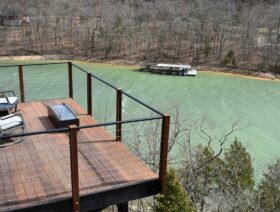 A view down onto one of the suspended, ipe (ironwood) decks of the Sky Suites complete with rocking chairs, fire table, and a commanding view of Beaver Lake.