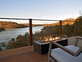 A scene from the elevated, front deck of a sky suite with the fire table in the foreground and Beaver Lake and the Ozark Mountains providing an amazing view.