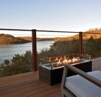 The mile long view of Beaver Lake and the Ozark Mountains as seen from one of the suspended decks with fire table and comfortable rockers available in the Sky Suites.