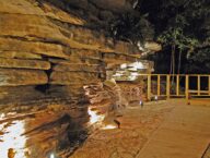 Mood lighting brings out features and shadows in the 14' tall natural bluff that forms one side of the private patio behind the Bluff Cabin.