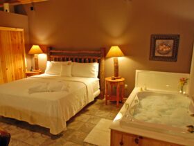 The king-size bed and the bubble-filled, 2-person Jacuzzi in our Bluff Cabin in the evening.